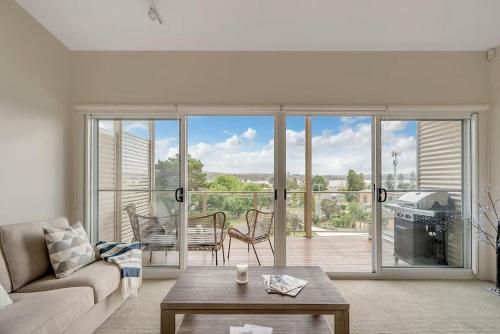 a living room with a couch and a table at Stunning water view Home moments from town in Batemans Bay