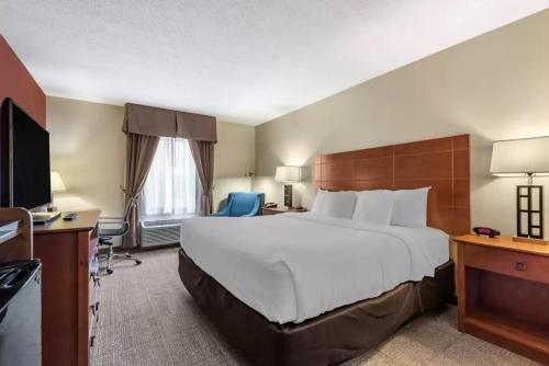 a hotel room with a large bed and a desk at Comfort Inn Augusta in Augusta