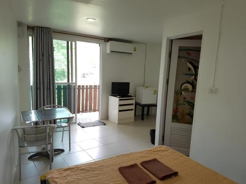 a bedroom with a bed and a table and a window at Keangvarin Resort in Ban Kaeng Manao