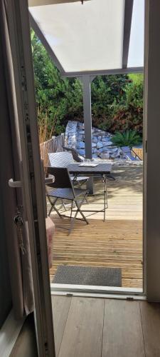 an open door to a patio with a table and a desk at LeMasBlanc, Chambre d'hôtes & jacuzzi privé, au calme, 15min de Carcassonne in Malves-en-Minervois