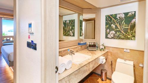 ein Badezimmer mit Waschbecken und Toilette und ein Bett in der Unterkunft Beyond Kata in Kata Beach