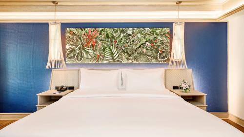 a bedroom with a large white bed and blue walls at Beyond Kata in Kata Beach