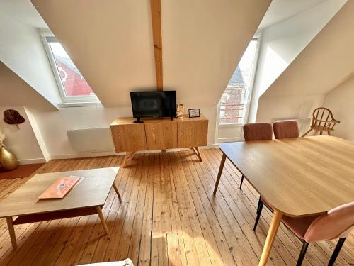 a living room with a table and a tv at T2 chaleureux - wifi - plage et commerces à pieds in Berck-sur-Mer