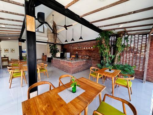 ein Esszimmer mit Holztischen und Stühlen in der Unterkunft Lubdhaka Canggu in Canggu