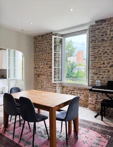 une salle à manger avec une table et des chaises en bois dans l'établissement L'Ossau - Rare et Atypique - Parking Privé, à Pau