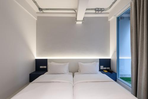 a bedroom with two beds and a window at Mowa Bangkok in Bangkok