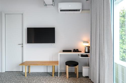 a room with a desk with a television and a stool at Mowa Bangkok in Bangkok
