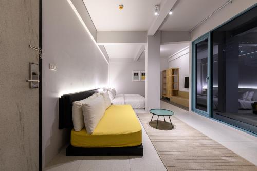 a bedroom with a yellow ottoman and a bed at Mowa Bangkok in Bangkok