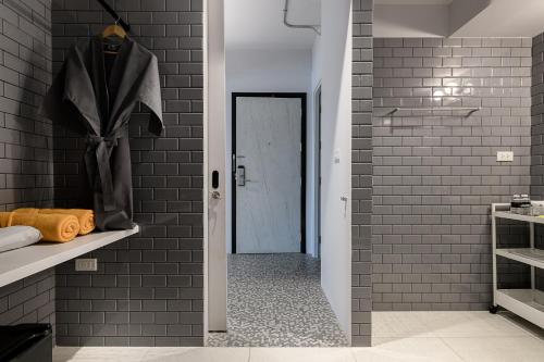 a bathroom with a brick wall and a walk in shower at Mowa Bangkok in Bangkok