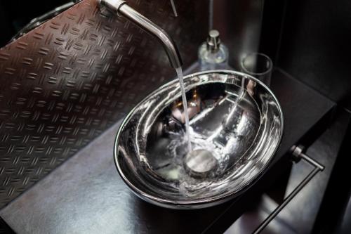 eine Glasschale mit einem Wasserbrunnen auf einem Tisch in der Unterkunft Industrial - Le Petit Bati in Volos