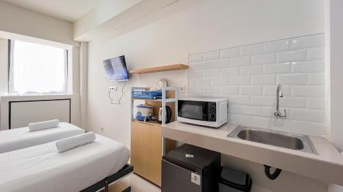 Un pat sau paturi într-o cameră la Restful Studio (No Kitchen) Apartment at Bandaraya - Tallasa City Makassar By Travelio