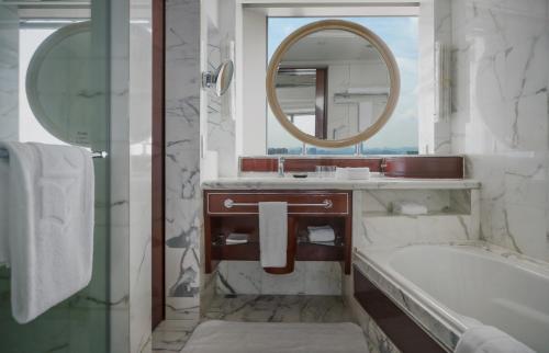 a bathroom with a tub and a sink and a mirror at Shangri-La Guangzhou-Walking to Canton Fair Complex in Guangzhou
