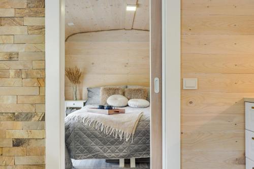 a bedroom with a bed with a wooden wall at Meldai in Pabradė