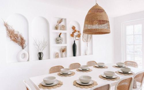 a white dining room with a white table and chairs at Our NEW 1940's Lovingly Renovated Cosy Cottage in McLaren Vale