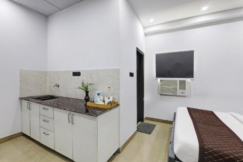 a white kitchen with a sink and a bed at Hotel The Rasa at Vasundhara in Ghaziabad
