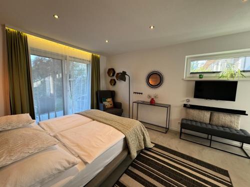 a bedroom with a bed and a flat screen tv at Kal's Studio Apartment Salzburg in Salzburg