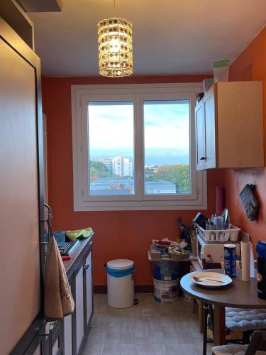 une cuisine aux murs orange et une fenêtre dans l'établissement Charmant Studio, à Nantes