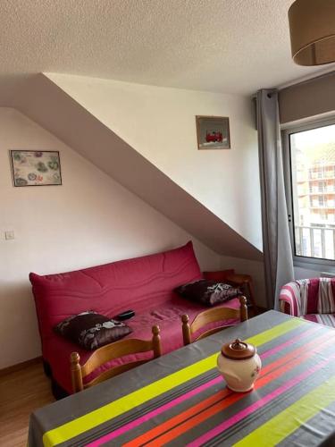 - une chambre avec un canapé rouge et une fenêtre dans l'établissement Duplex à 100m de la plage, à Neufchâtel-Hardelot