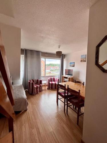 un salon avec une table et des chaises et une salle à manger dans l'établissement Duplex à 100m de la plage, à Neufchâtel-Hardelot