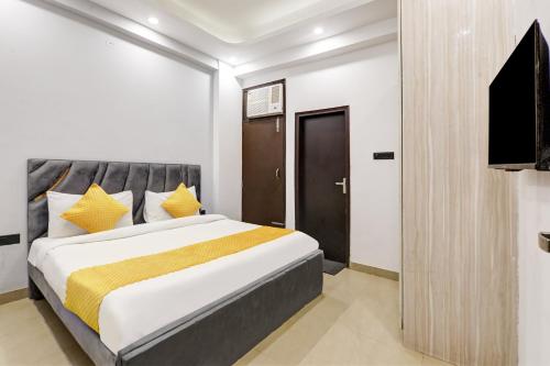 a bedroom with a bed and a flat screen tv at Hotel The Rasa at Vasundhara in Ghaziabad