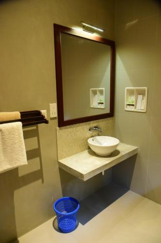 a bathroom with a sink and a mirror at Tranquil in Hikkaduwa