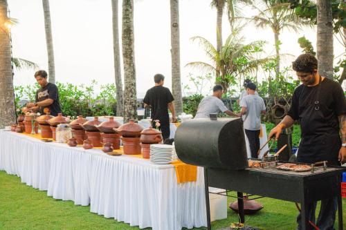 a group of people preparing food on a table at Villa Prinsessa in Siyut