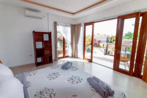 ein Schlafzimmer mit einem Bett in einem Zimmer mit Glasschiebetüren in der Unterkunft Villa Shantia by Bby Diamond in Legian