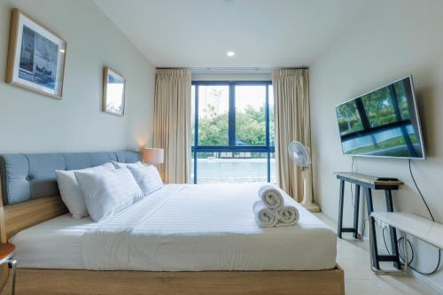 a bedroom with a large white bed and a window at Beach Front Condo, Baan Thew Talay, Perfect Choice for Family and Couple in Ban Bo Khaem