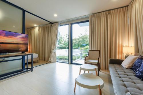 a living room with a couch and a tv at Beach Front Condo, Baan Thew Talay, Perfect Choice for Family and Couple in Ban Bo Khaem