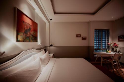 a bedroom with a white bed and a table at Au Lac Boutique Hotel in Ho Chi Minh City