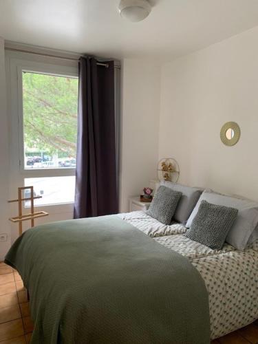 une chambre avec un lit avec des oreillers et une fenêtre dans l'établissement Beau T2 clim terrasse idéalement situé, à Aix-en-Provence