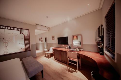 a living room with a desk and a tv at Au Lac Boutique Hotel in Ho Chi Minh City