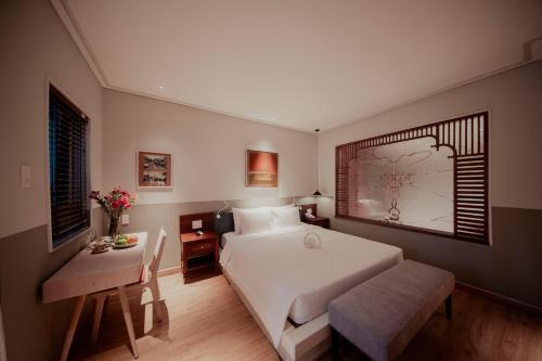 a bedroom with a bed and a table and a desk at Au Lac Boutique Hotel in Ho Chi Minh City