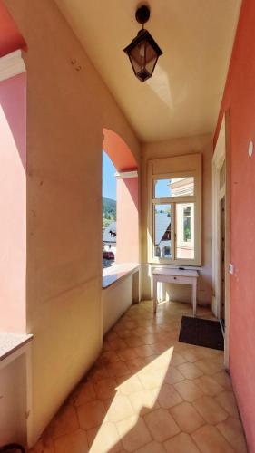 an empty hallway with a window and a table at Villa Rosa Tarvisio in Tarvisio