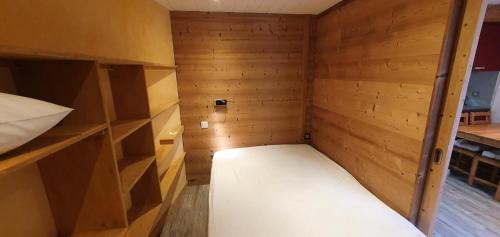 Cette petite chambre dispose d'un lit et de murs en bois. dans l'établissement Résidence Melezets 3 - 2 pièces 4 personnes MAE-0601, à Modane