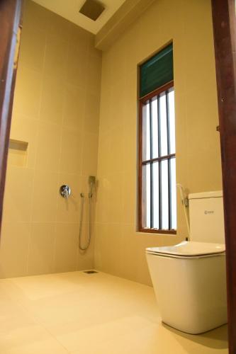 a bathroom with a toilet and a shower at Tranquil in Hikkaduwa