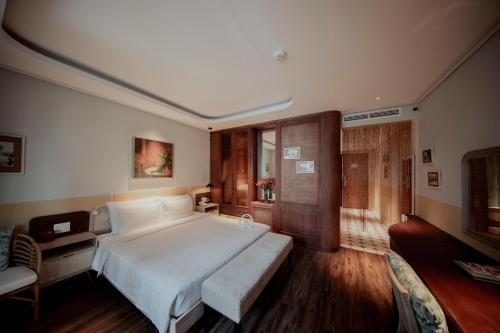 a bedroom with a large white bed and a couch at Au Lac Boutique Hotel in Ho Chi Minh City