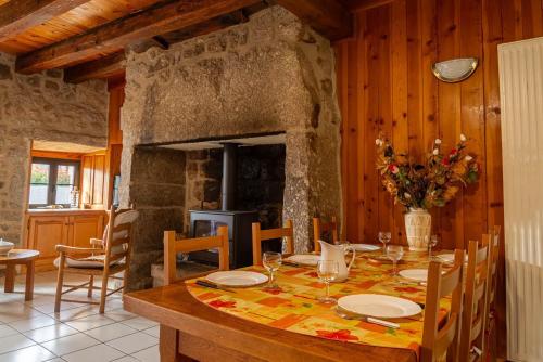une salle à manger avec une table et une cheminée dans l'établissement Gites de france de la fage montivernoux, à Saint-Laurent-de-Veyrès