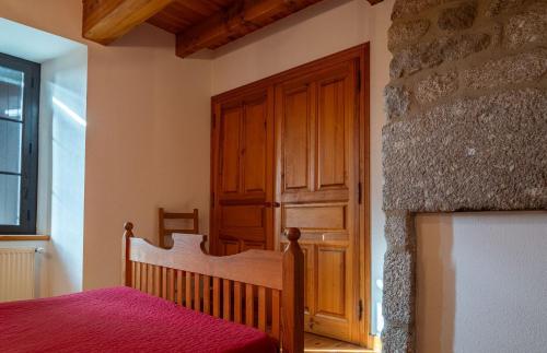 a bedroom with a bed and a wooden door at Gites de france de la fage montivernoux in Saint-Laurent-de-Veyrès