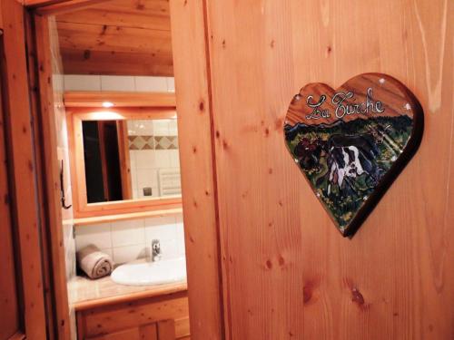 un cœur accroché au mur d'une salle de bain dans l'établissement Chalet L'hermine - Confort et authenticité proche des pistes MAE-3391, aux Gets