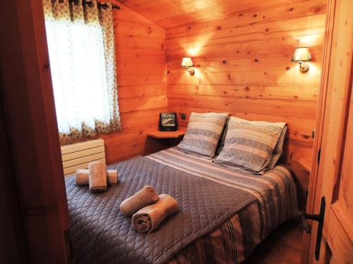 une chambre avec un lit dans une cabane en rondins dans l'établissement Chalet L'hermine - Confort et authenticité proche des pistes MAE-3391, aux Gets