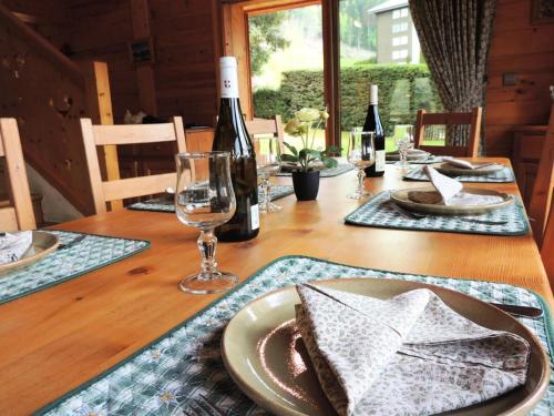 - une table en bois avec une assiette de bouteilles de nourriture et de vin dans l'établissement Chalet L'hermine - Confort et authenticité proche des pistes MAE-3391, aux Gets