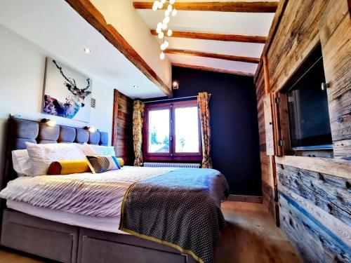 une chambre avec un grand lit dans une pièce dans l'établissement Chalet La SilÈne - Chalet de charme aux Chavannes avec vue et confort MAE-3411, aux Gets