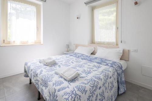 a white bedroom with a bed with two towels on it at IseoLakeRental - Blu Lago in Predore