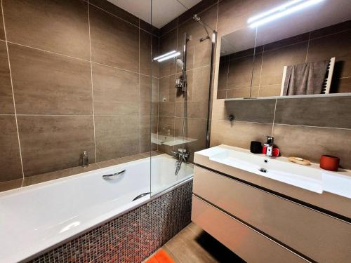 une salle de bain avec une baignoire et un lavabo et une baignoire dans l'établissement Résidence Les OrÉades - Appartement à seulement 20m des pistes de la Turche MAE-3431, aux Gets