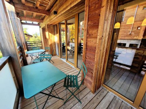 - une table et des chaises sur la terrasse couverte d'une cabine dans l'établissement Résidence Les OrÉades - Appartement à seulement 20m des pistes de la Turche MAE-3431, aux Gets