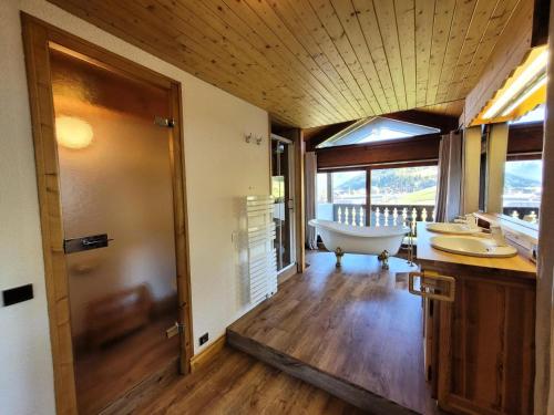 La salle de bains est pourvue d'une baignoire, de 2 lavabos et d'une baignoire. dans l'établissement Résidence Le Chene - Très bel appartement de type 6 pièces pied des pistes au centre du village MAE-3381, aux Gets