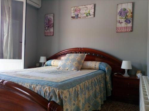 a bedroom with a bed with a wooden head board at Casa Los Pinos in Siles