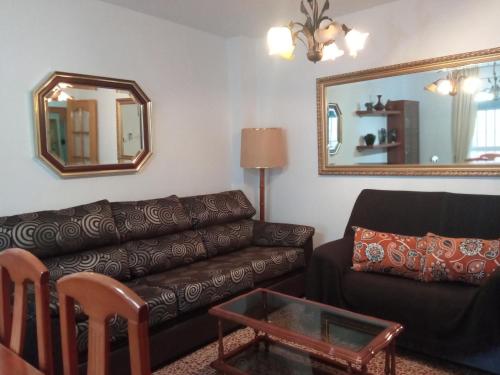 a living room with a couch and a mirror at Casa Los Pinos in Siles