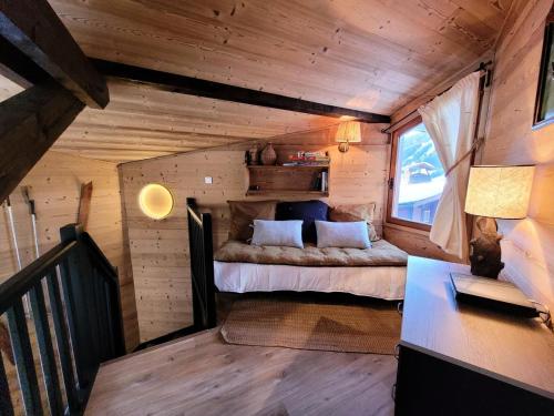 une chambre dans une cabane en rondins avec un lit dans l'établissement Résidence Les PrÉs D'hastings - Chalet cocooning Ambiance montagnarde & jardin MAE-3471, aux Gets